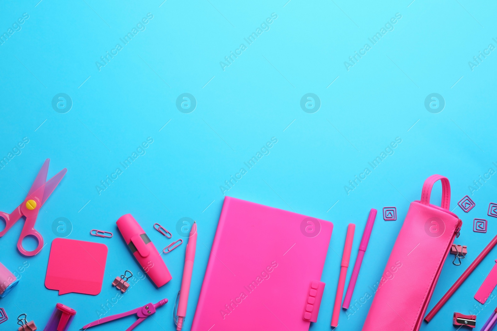 Photo of Colorful school stationery on light blue background, flat lay. Space for text