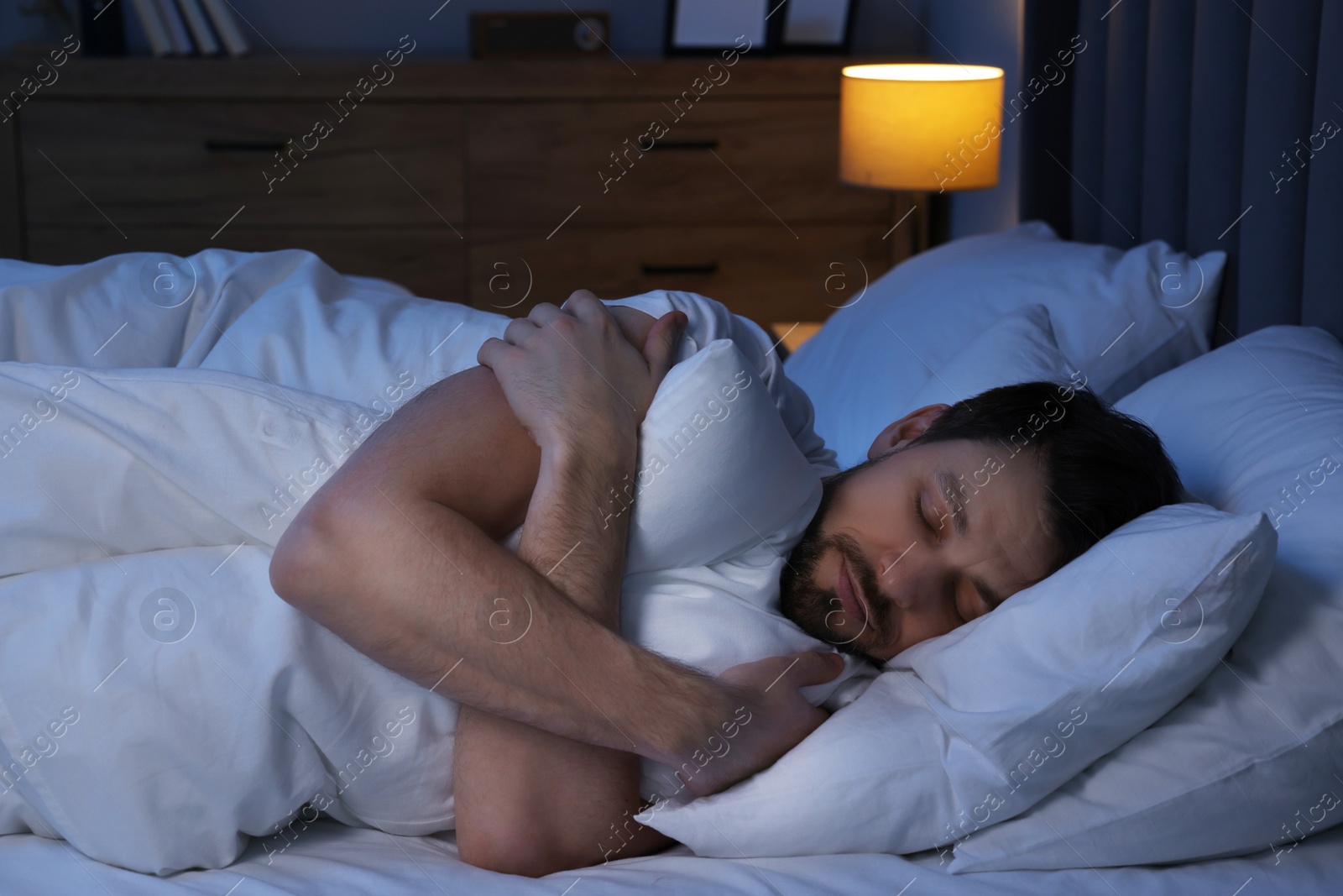 Photo of Handsome man sleeping in bed at night