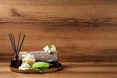 Photo of Aromatic sea salt and spa products on wooden table, space for text