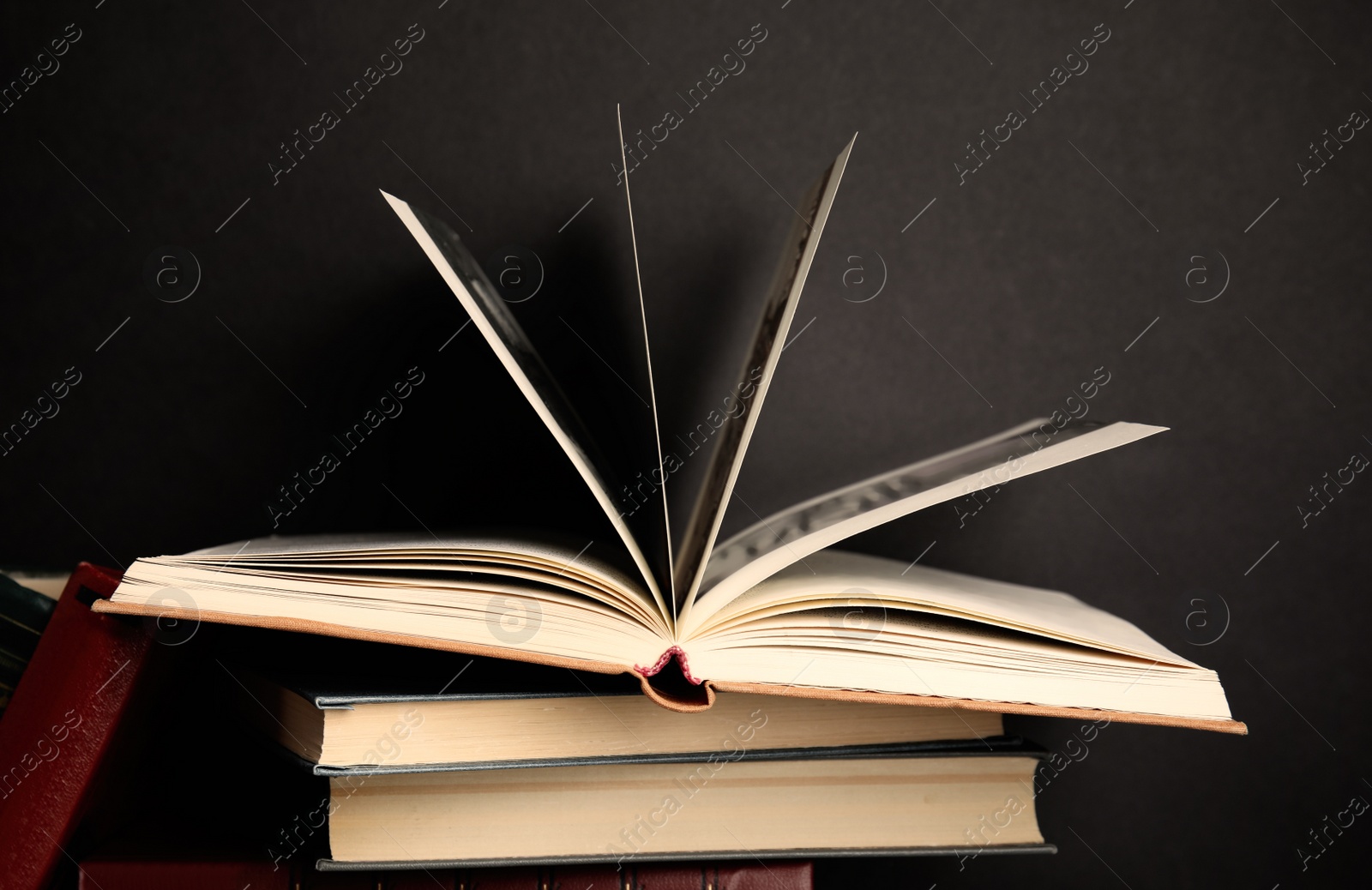 Photo of Different old hardcover books against black background