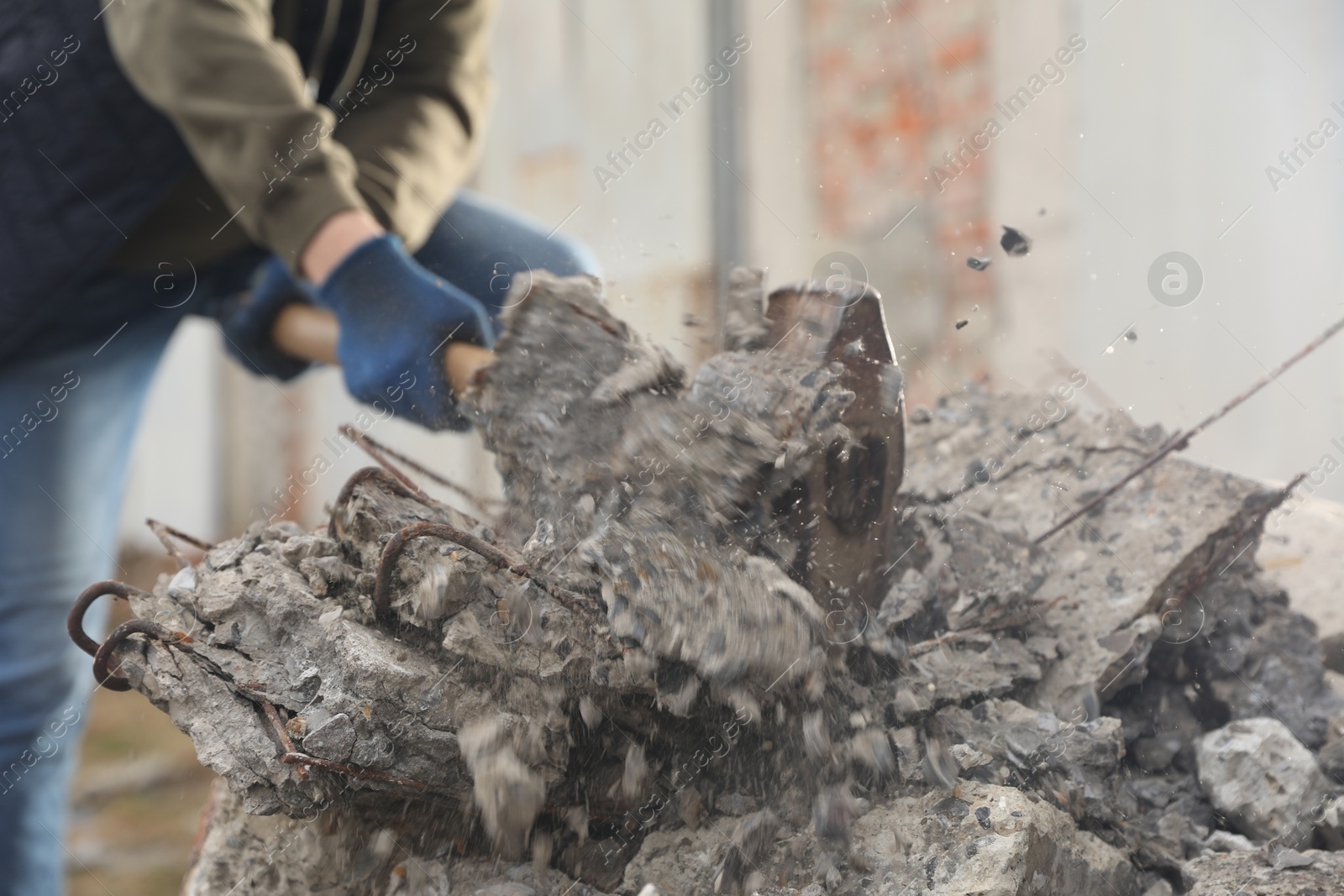 Photo of Man breaking stones with sledgehammer outdoors, closeup