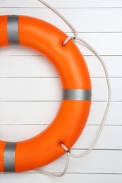 Photo of Orange lifebuoy on white wooden background. Rescue equipment