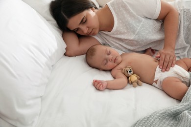 Photo of Mother with her cute baby sleeping in bed