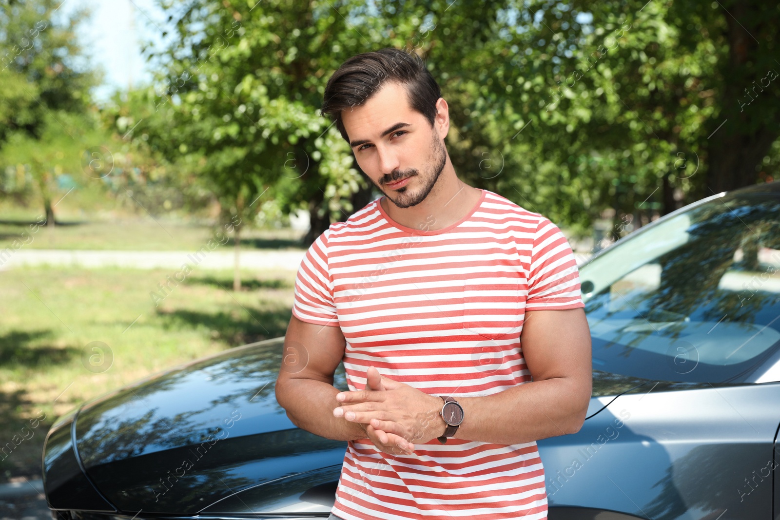 Photo of Attractive young man near luxury car outdoors