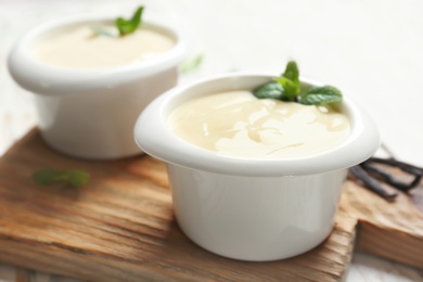 Vanilla pudding, sticks and fresh mint on wooden board