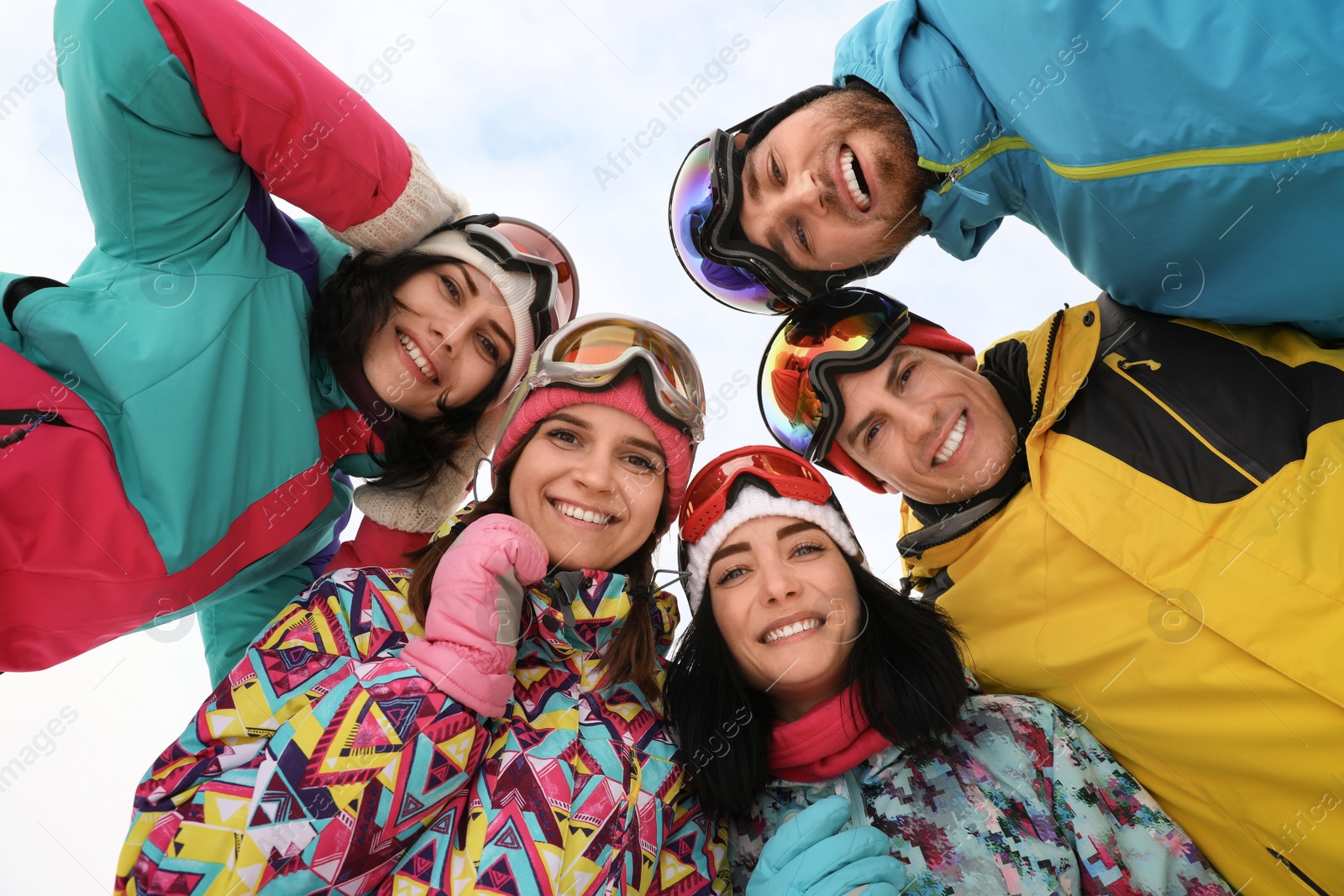 Photo of Group of friends joined in circle outdoors, bottom view. Winter vacation