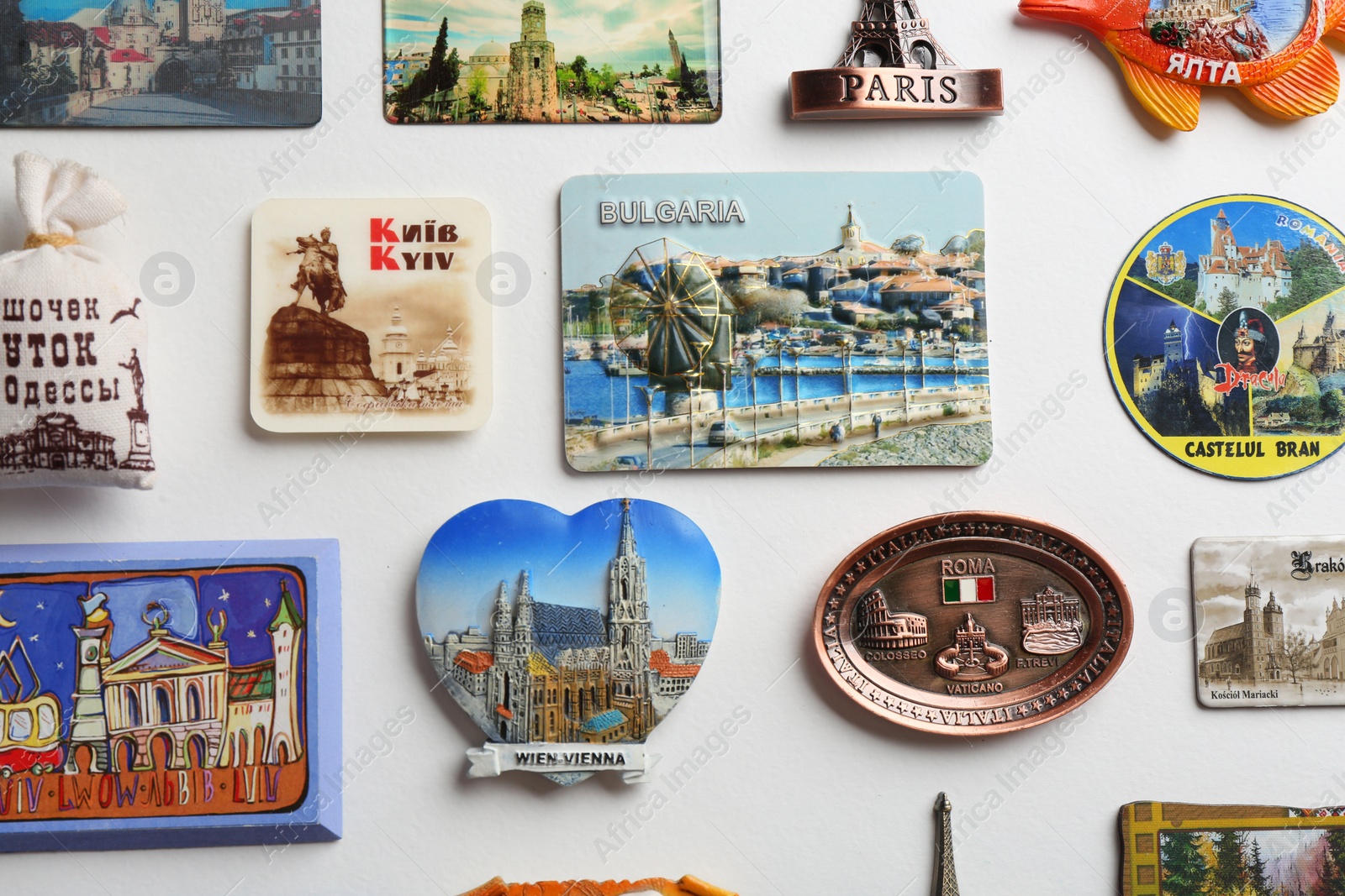 Photo of MYKOLAIV, UKRAINE - DECEMBER 25, 2018: Many different souvenir magnets on white background, flat lay