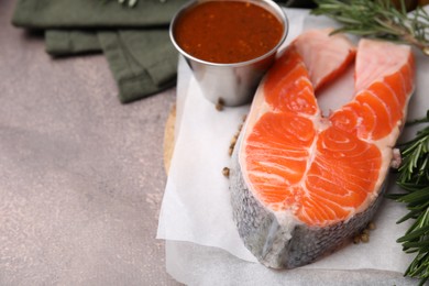 Photo of Fresh fish, rosemary and marinade on brown textured table, closeup. Space for text