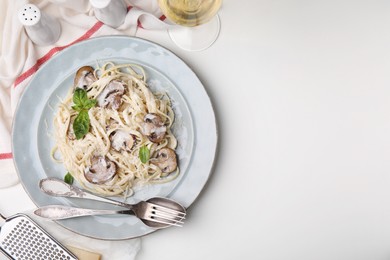 Photo of Delicious pasta with mushrooms and cheese served on white table, flat lay. Space for text