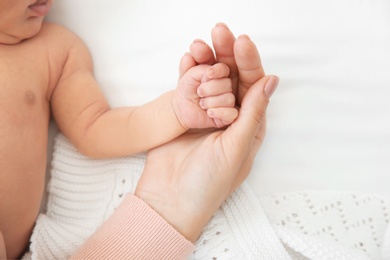 Mother holding little baby hand