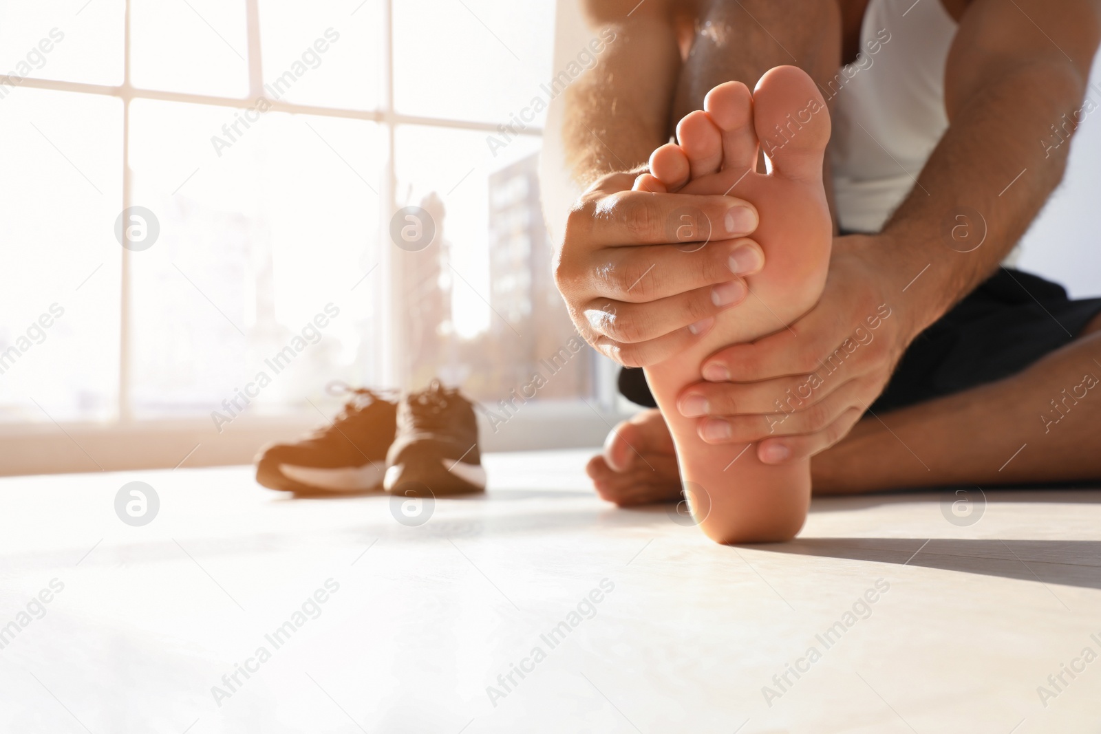 Photo of Man suffering from foot pain indoors, closeup. Space for text