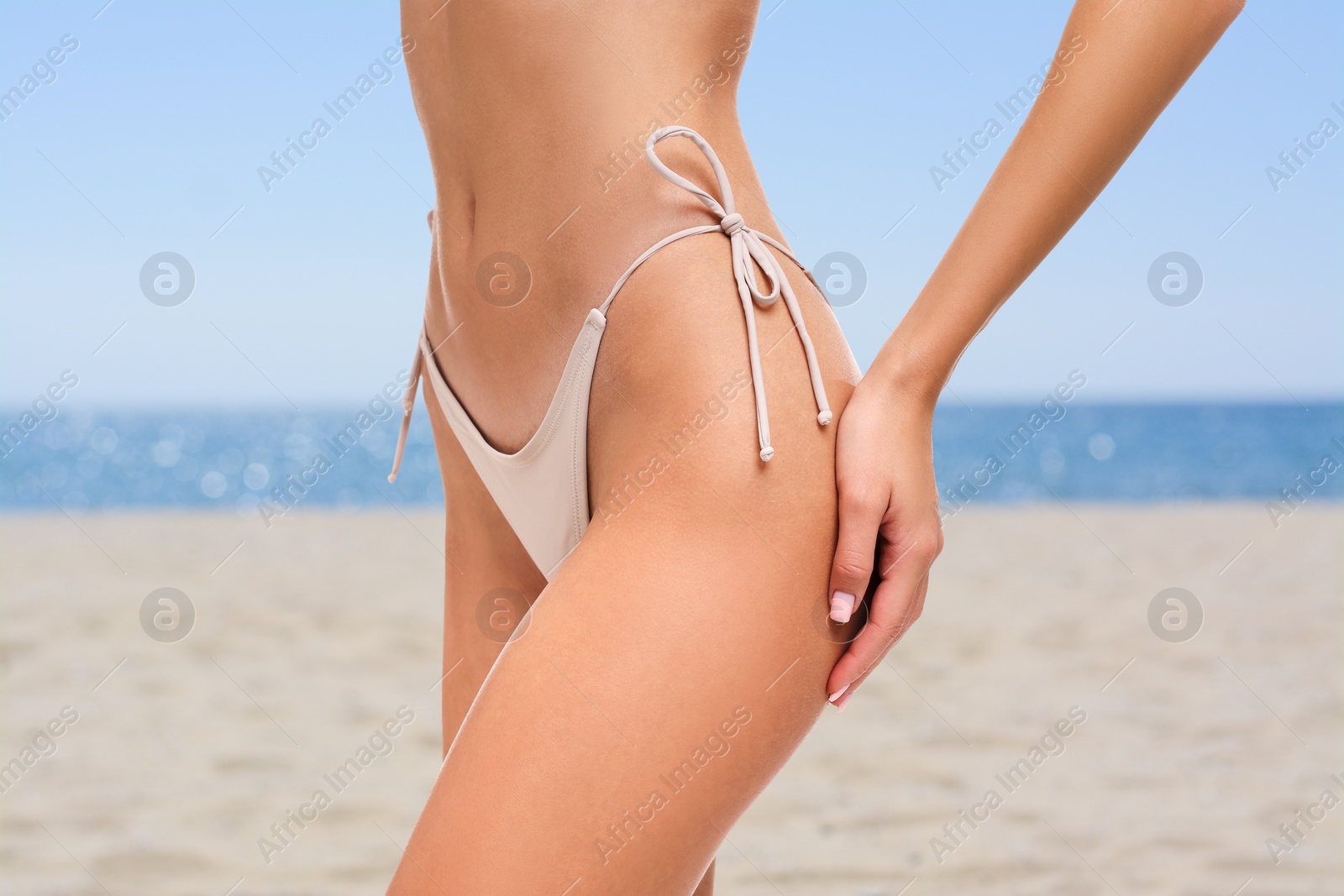 Image of Woman in stylish bikini on sandy beach near sea, closeup