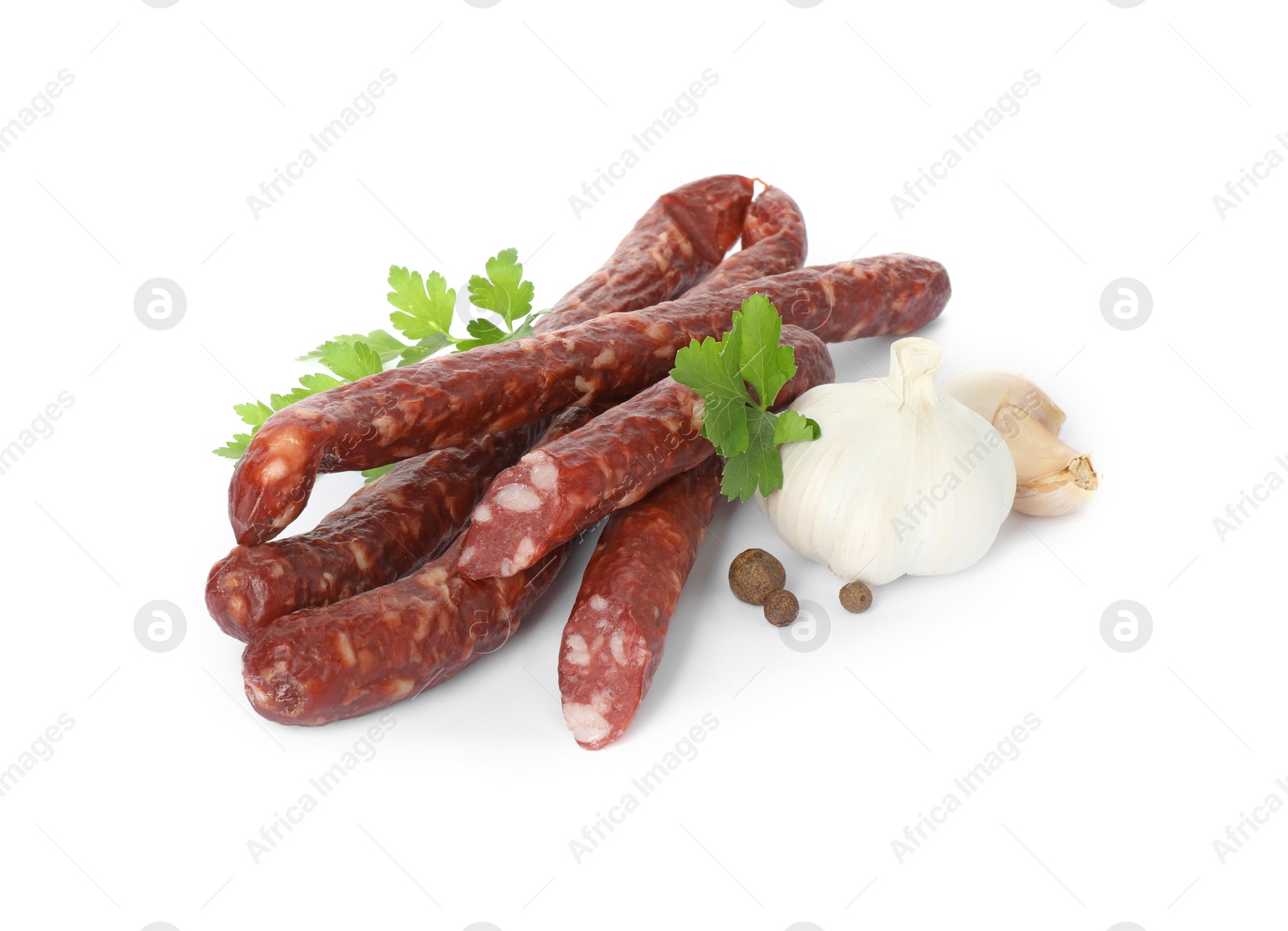 Photo of Thin dry smoked sausages and different spices isolated on white