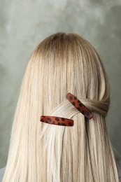 Photo of Young woman with beautiful hair clips on grey background, back view