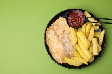 Photo of Delicious fish and chips with ketchup on green table, top view. Space for text