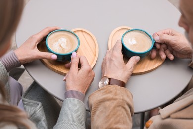 Affectionate senior couple with coffee at table, closeup