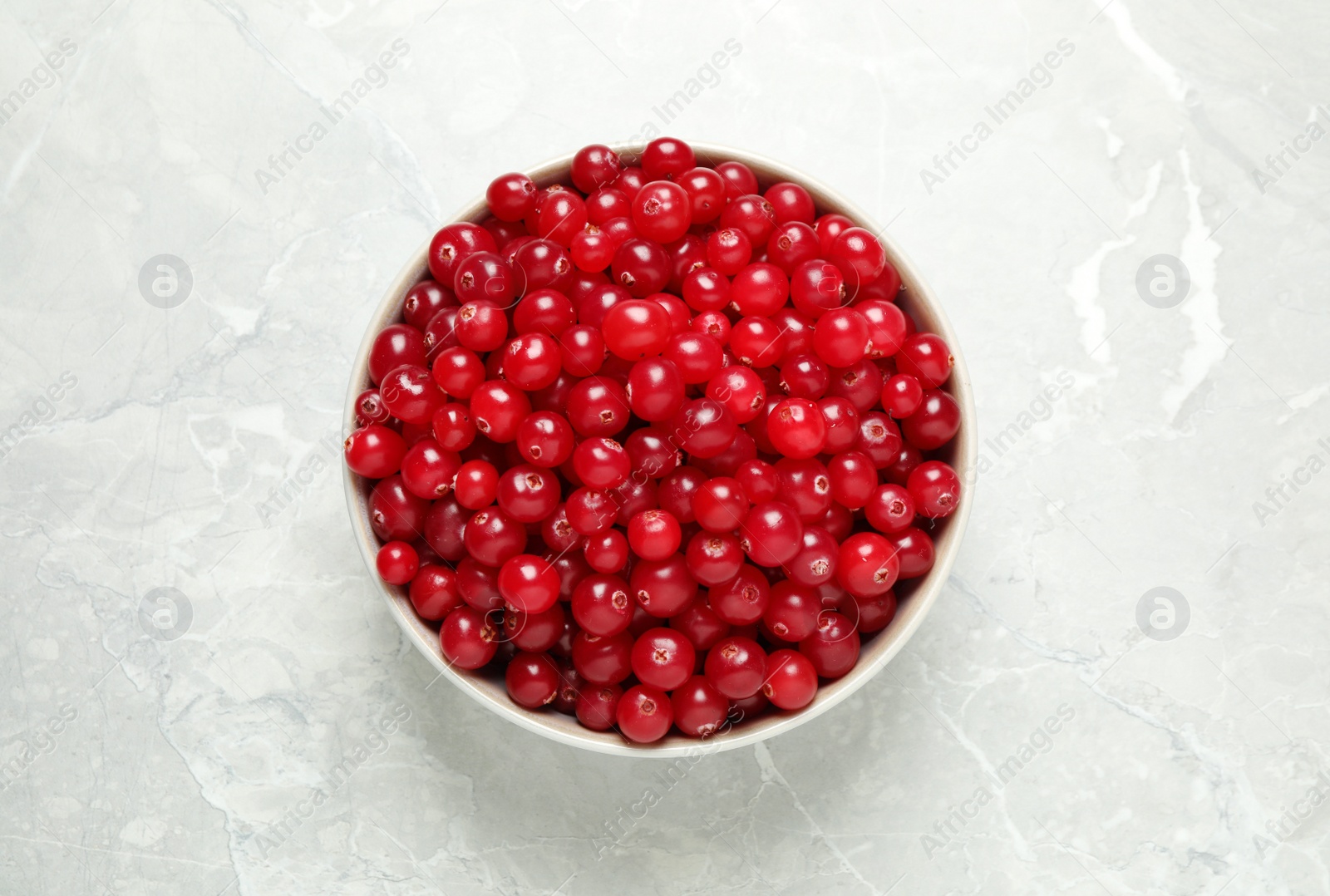 Photo of Tasty ripe cranberries on light grey marble table, top view