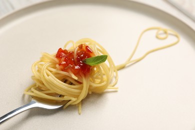 Photo of Heart made with spaghetti and fork on plate, closeup