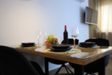 Photo of Blurred view of elegant table setting for dinner indoors