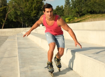 Photo of Handsome young man roller skating on city street