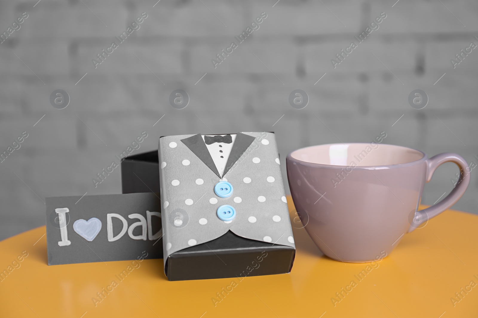 Photo of Cup and gift box on table. Father's day celebration