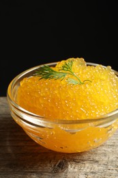 Fresh pike caviar in bowl on wooden table, closeup