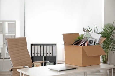 Cardboard box full of stuff on table in office