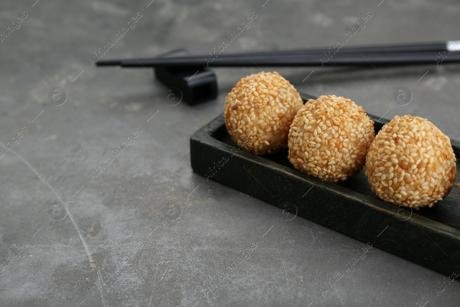 Photo of Delicious sesame balls on grey table. Space for text