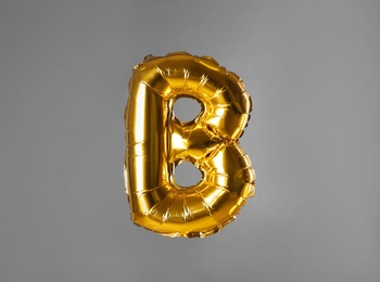 Photo of Golden letter B balloon on grey background