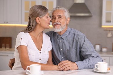 Photo of Portrait of affectionate senior couple in kitchen