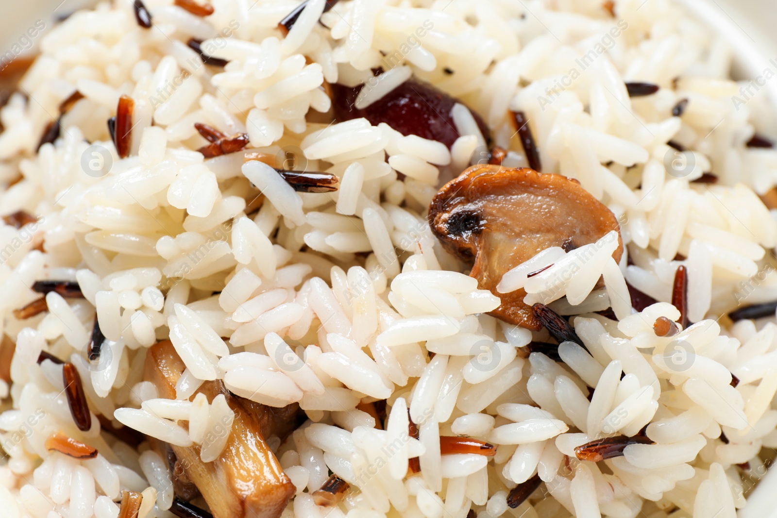 Photo of Delicious rice pilaf with mushrooms as background, closeup