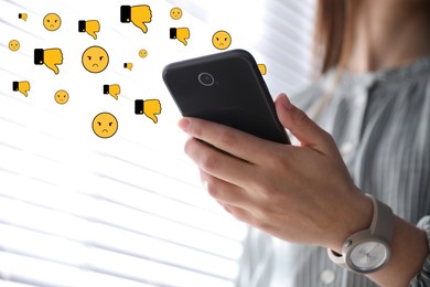 Image of Social media dislike reaction. Woman using mobile phone indoors, closeup. Thumbs down and angry face emoji illustrations over gadget