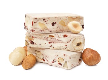 Photo of Pieces of delicious nougat and nuts on white background