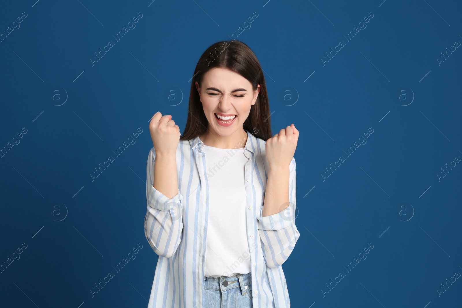 Photo of Portrait of excited young woman on blue background