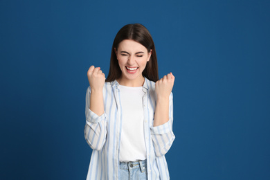 Photo of Portrait of excited young woman on blue background