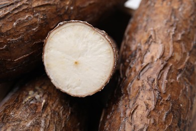 Whole and cut cassava roots as background, closeup