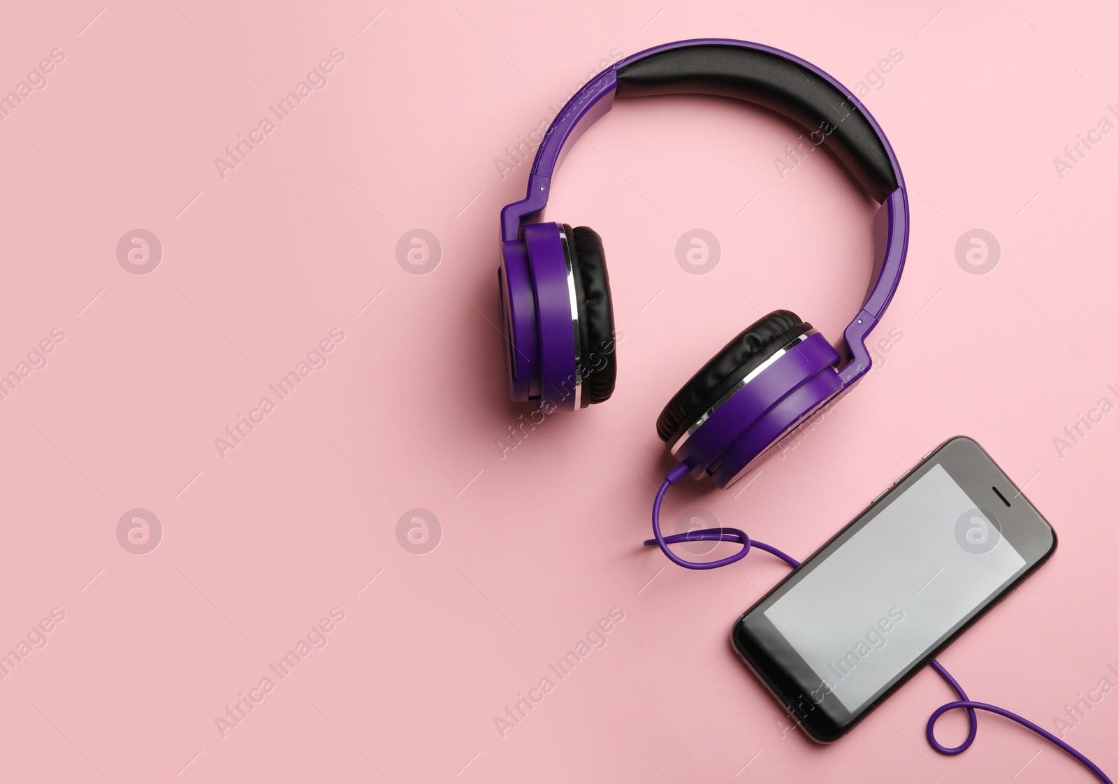 Photo of Stylish headphones and modern phone on color background, flat lay. Space for text