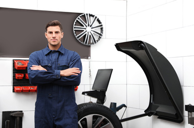 Man near wheel balancing machine at tire service