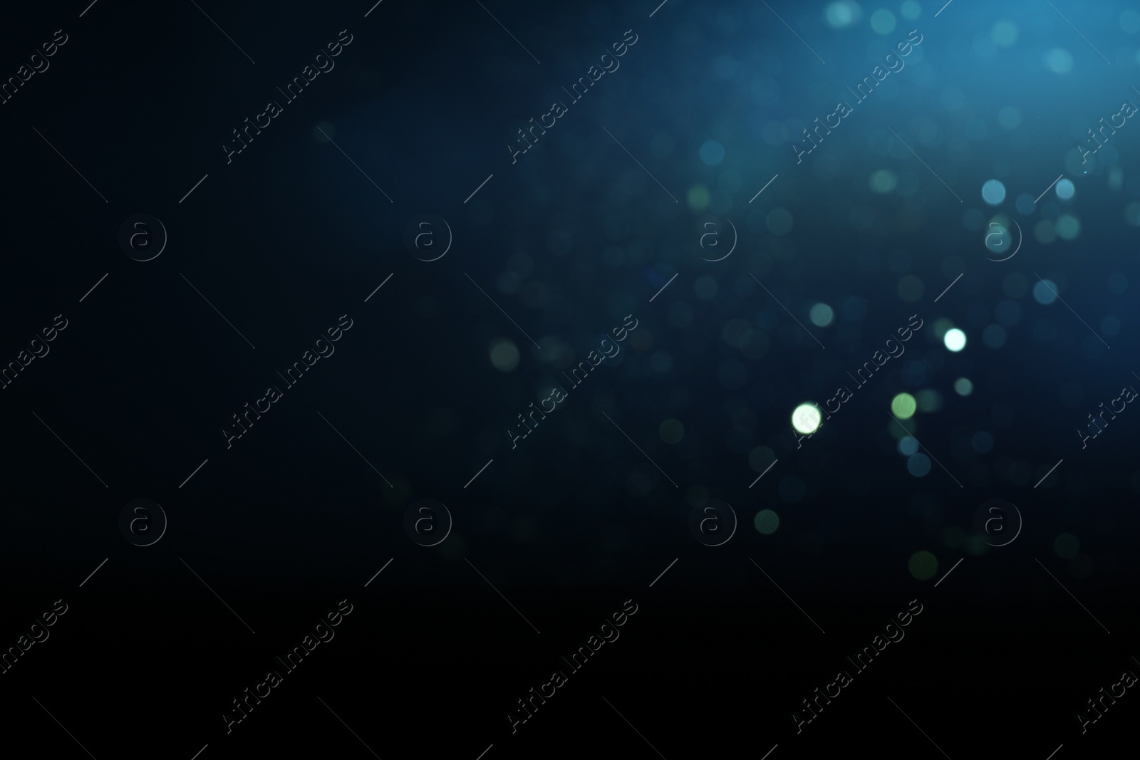 Photo of Blurred view of festive lights on blue background, space for text. Bokeh effect