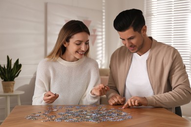 Happy couple playing with puzzles at home