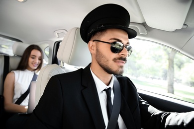 Photo of Handsome driver and young businesswoman in luxury car. Chauffeur service