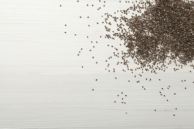 Photo of Chia seeds on white wooden table, flat lay. Space for text