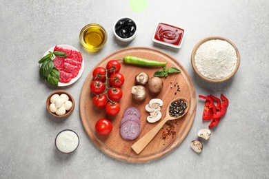 Photo of Flat lay composition with fresh ingredients for pizza on grey table