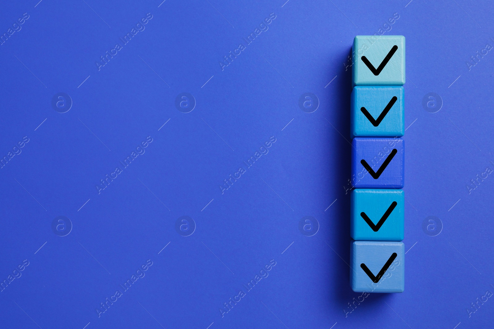 Image of Cubes with check marks on blue background, top view. Space for text