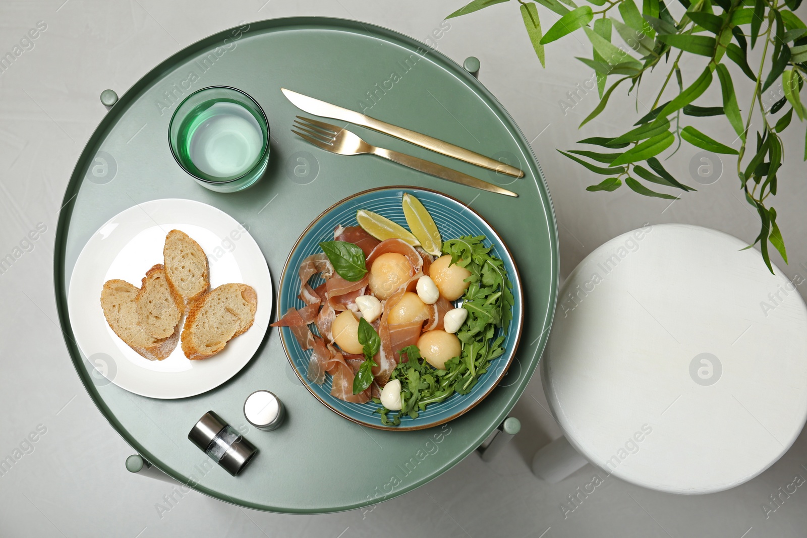 Photo of Flat lay composition with melon and prosciutto appetizer served on table