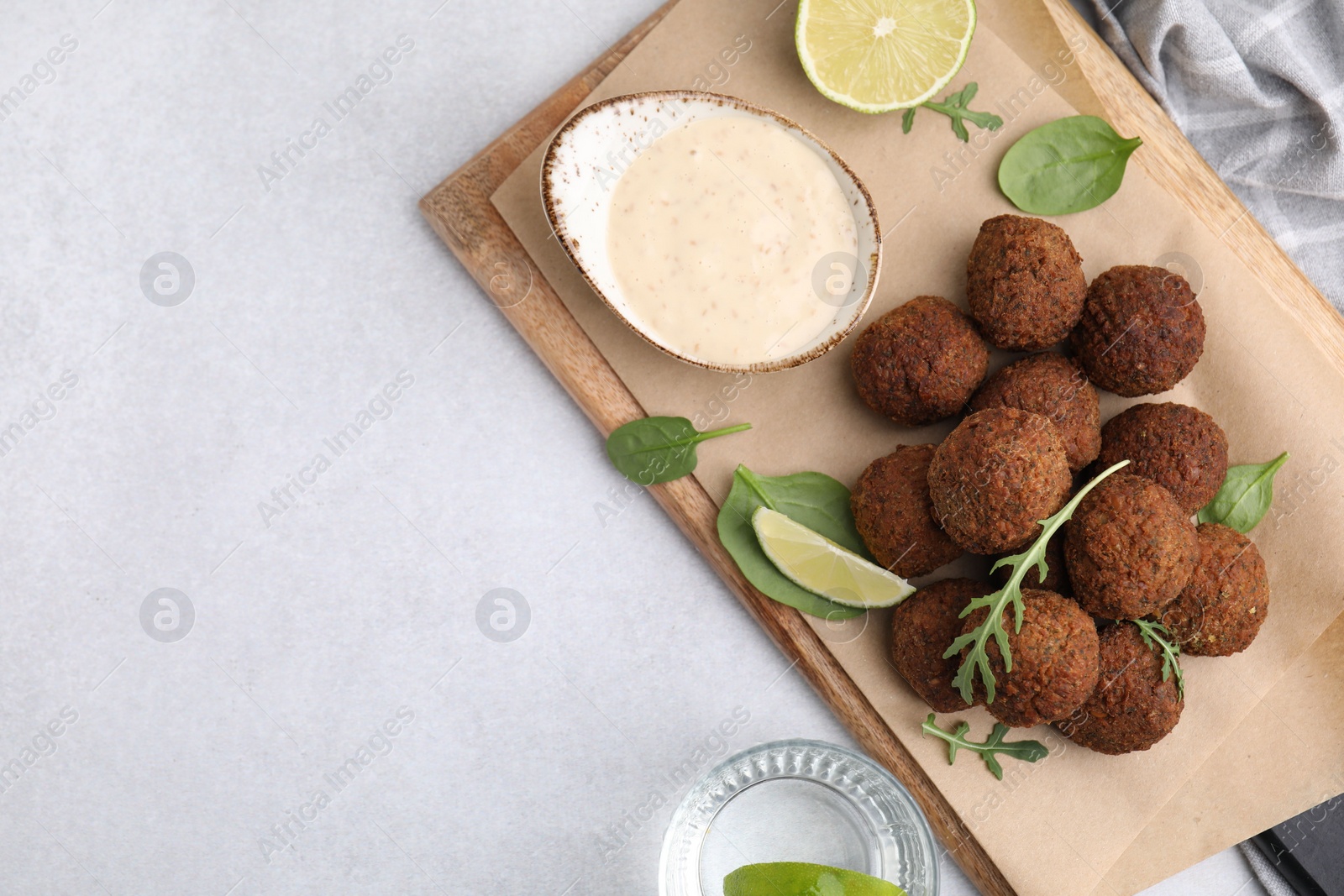 Photo of Delicious falafel balls served on light table, top view. Space for text