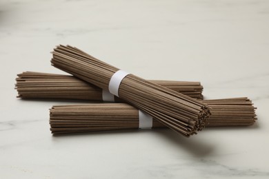 Uncooked buckwheat noodles (soba) on white marble table