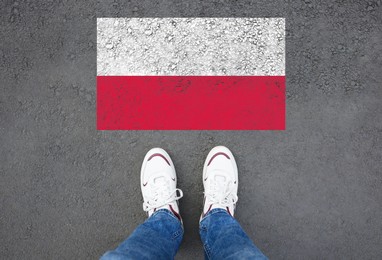 Image of Immigration. Man standing on asphalt near flag of Poland, top view