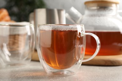 Photo of Aromatic tea in glass cup on light grey table