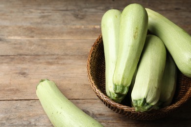 Photo of Ripe zucchinis on wooden table. Space for text